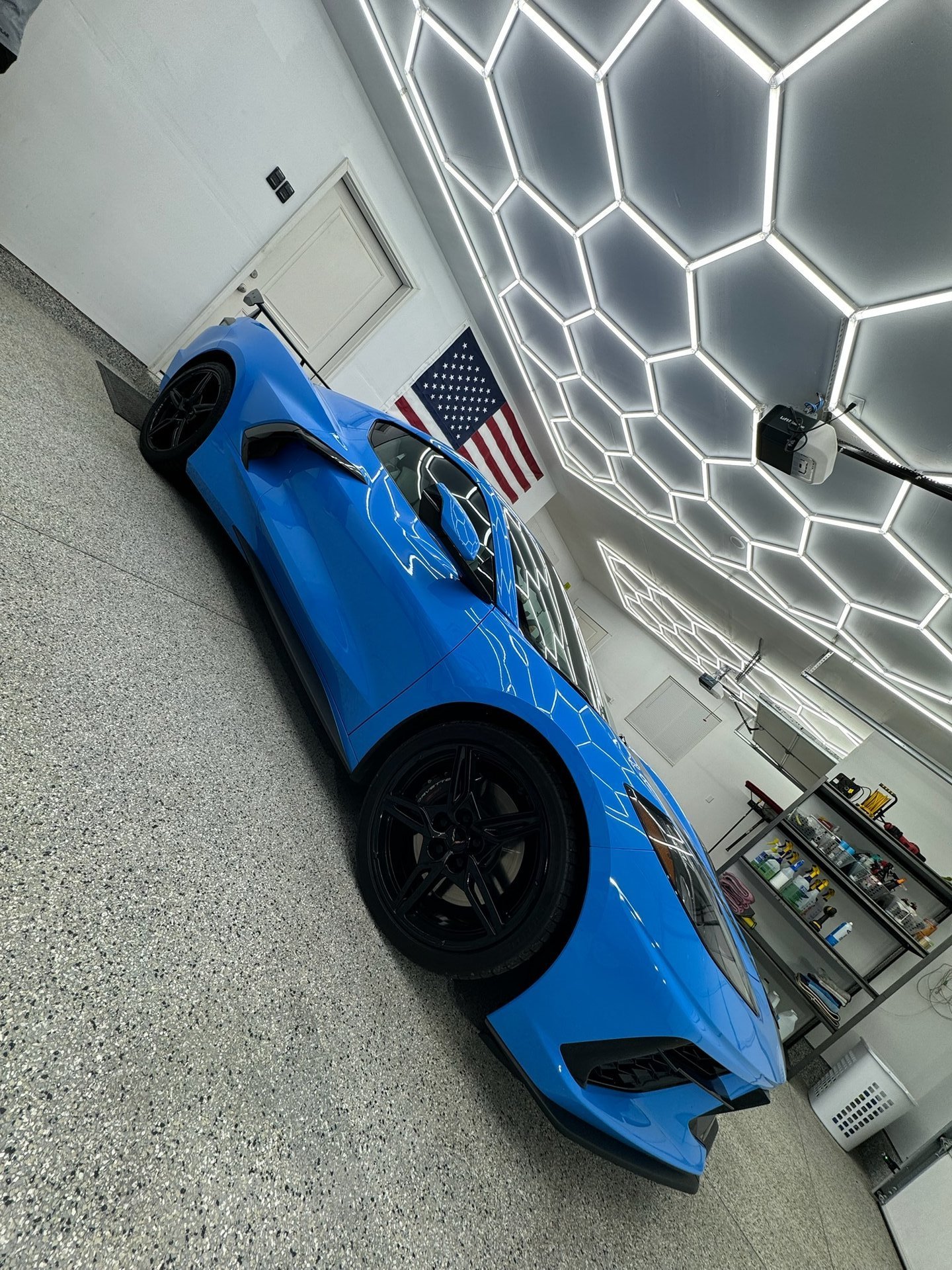 Showroom garage with hex ceiling and blue sports car